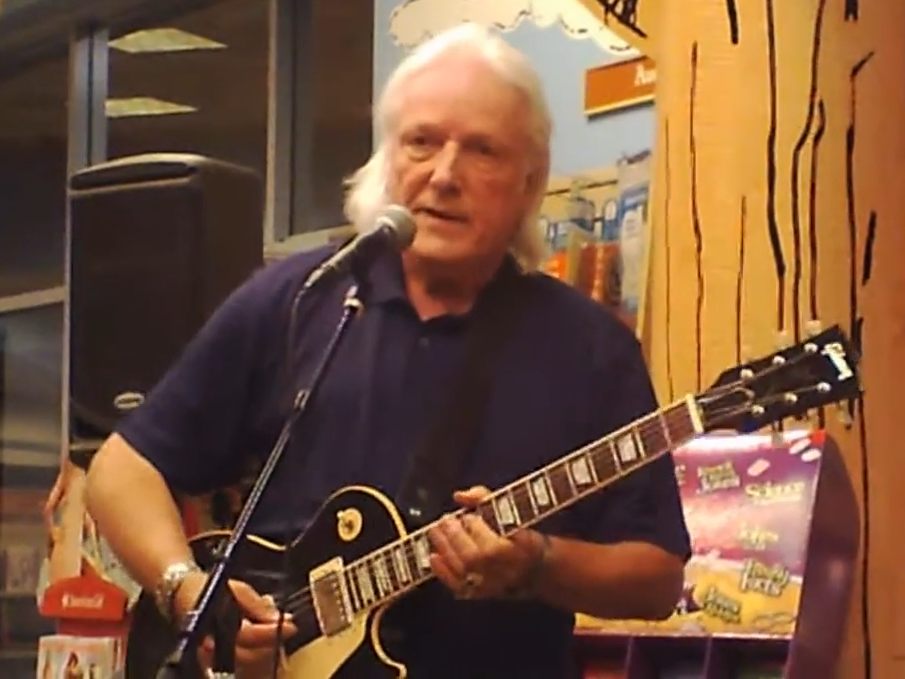 Dick Wagner playing a black Gibson Les Paul at a microphone in Scottsdale in 2012