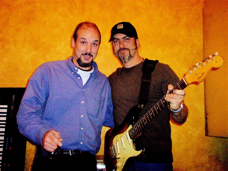 Steve Farris, at right, holding a Fender Stratocaster beside CJ Sorg