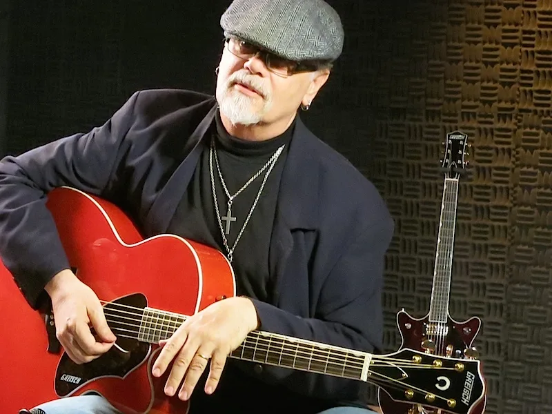 Steve Hunter seated with a guitar in a recording studio in 2013
