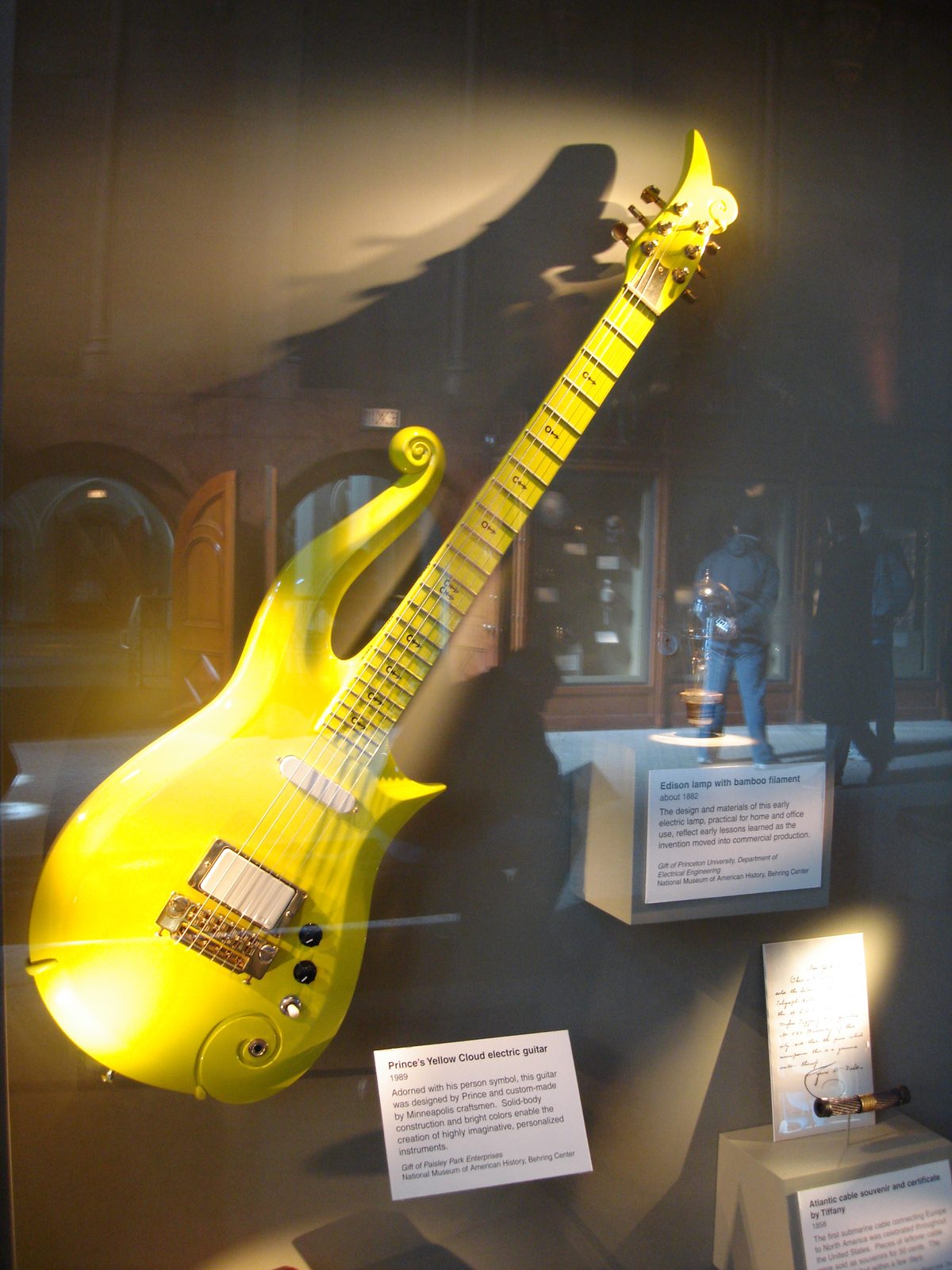 A Yellow Cloud electric guitar of the type played by Prince, on display in a museum case