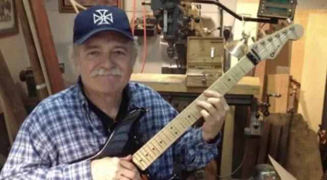 Wayne Charvel in his workshop, holding an unfinished guitar by the neck