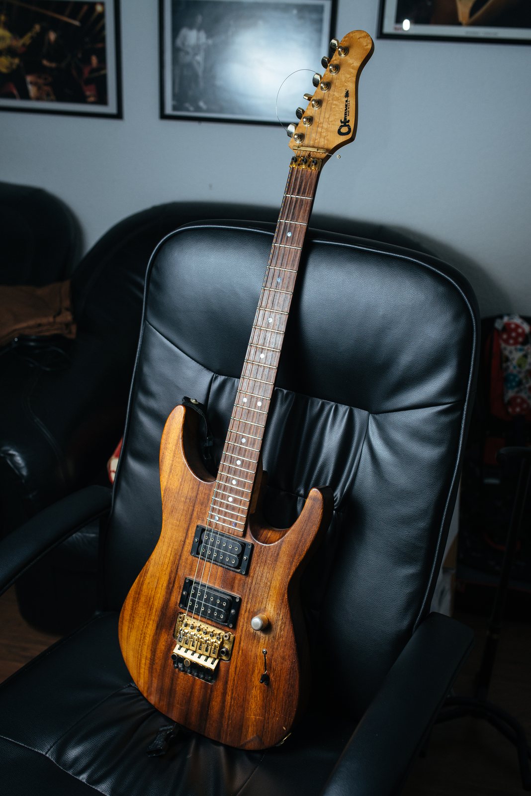 A Charvel San Dimas electric guitar with a koa body resting on an armchair